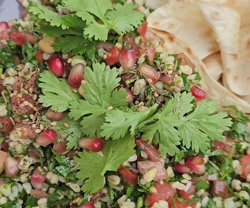 Sałatka tabbouleh z granatem i kolendrą na talerzu