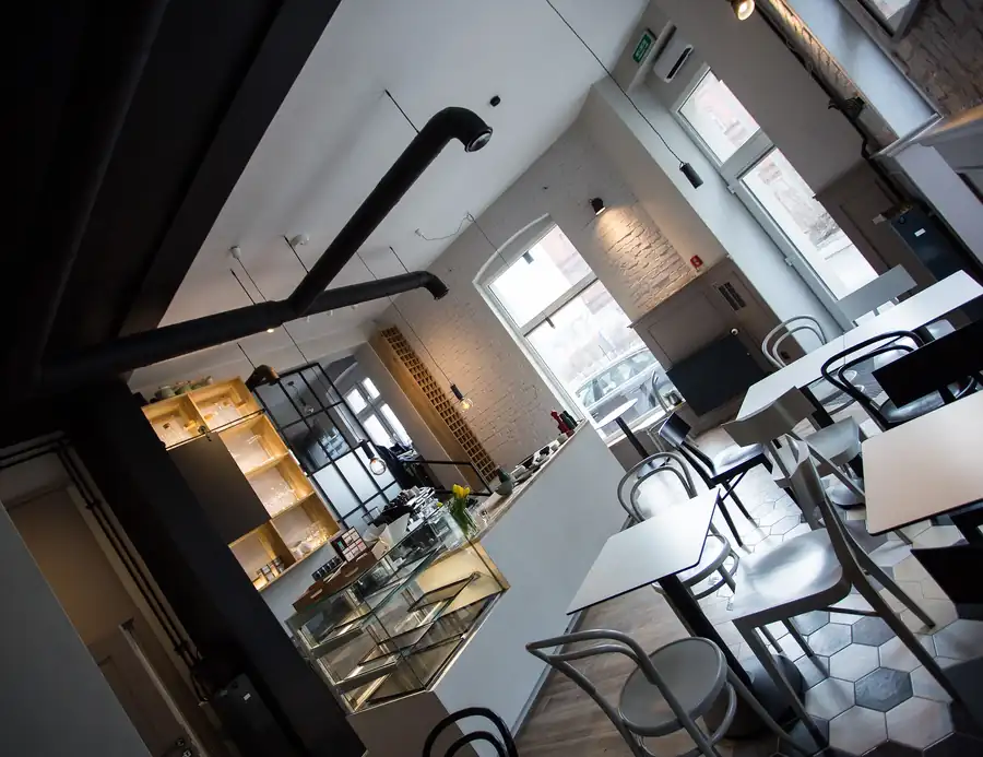 Jasne wnętrze Bulwar Bistro z białymi stolikami i dużymi oknami